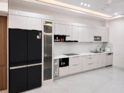 Mẫu tủ bếp inox cánh kính hiện đại thiết kế tone trắng tinh tế, kết hợp mặt đá vân mây cao cấp giúp không gian bếp rộng rãi và sang trọng hơn.